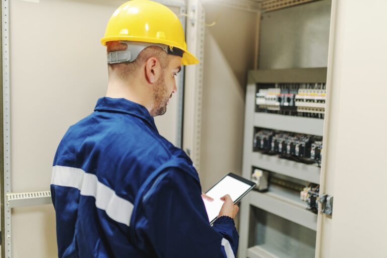 Électricien H0 B0 effectuant un contrôle sur un tableau électrique