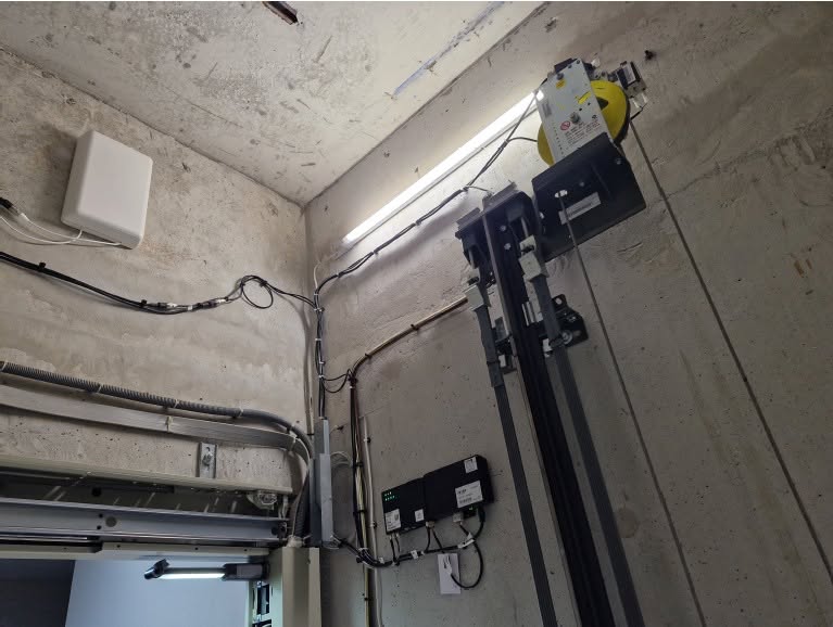 Vue intérieure d'une cage d'ascenseur avec des équipements et installations électriques